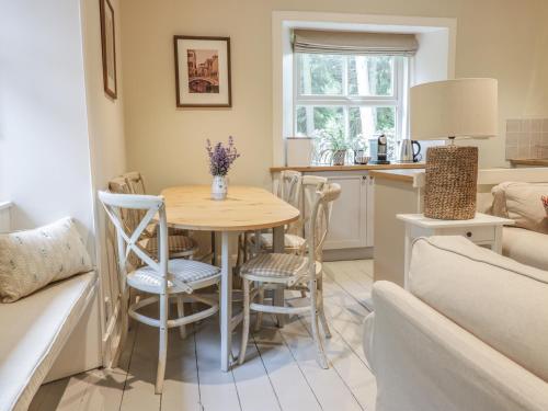 a kitchen and living room with a table and chairs at Gate Lodge in West Calder