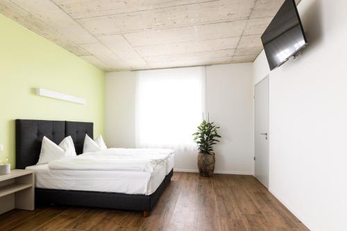 a bedroom with a bed and a flat screen tv at Partner Hotel AG Zofingen in Zofingen
