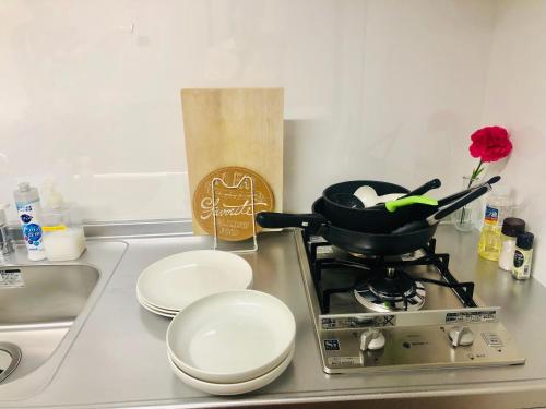 a kitchen counter with a stove with a pan on it at 板橋 RCアネックス Rc302 in Tokyo