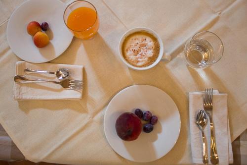 a table with plates of food and glasses of orange juice at Agriturismo La Cà Veja in Monforte dʼAlba