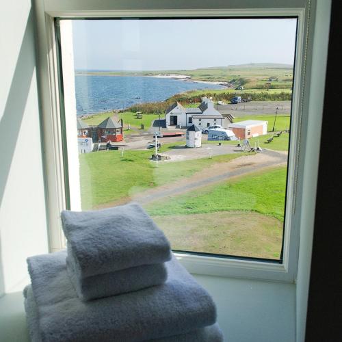 a window with a pile of towels on a chair at John O'Groats in John O Groats