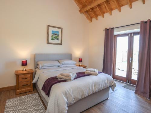 a bedroom with a bed and a large window at Y Bwthyn in Llanfairpwllgwyngyll