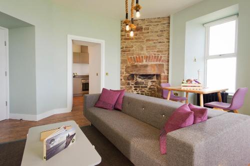 a living room with a couch and a brick wall at John O'Groats in John O Groats