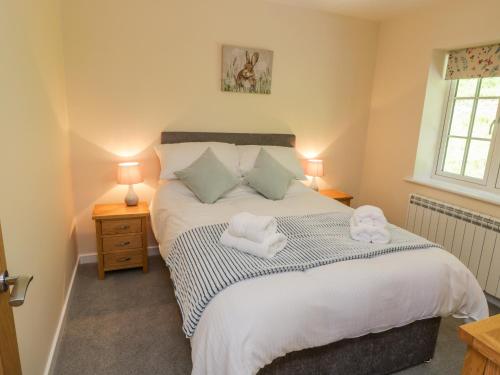 a bedroom with a bed with towels on it at Ryedale Country Lodges - Willow Lodge in York