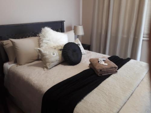 a bed with two pillows and a purse on it at KIHARA GUESTHOUSE in Bethlehem