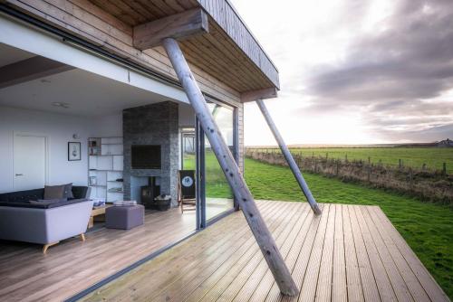 a house with a large wooden deck with a view at John O'Groats in John O Groats