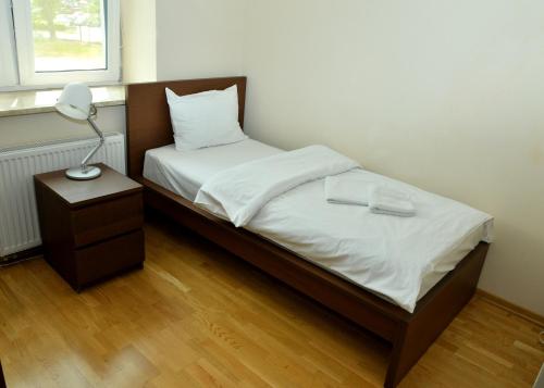 a bedroom with a bed with a lamp on a table at Brooklyn Noclegi in Jasło
