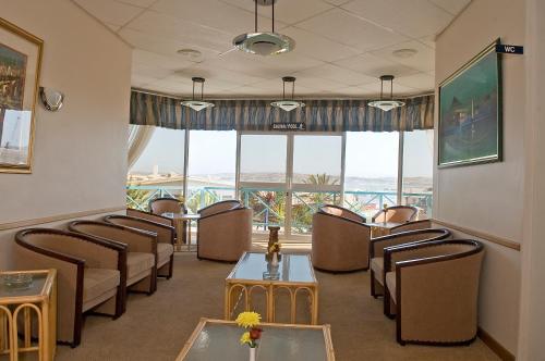 a waiting room with chairs and tables and windows at Sea-View Zum Sperrgebiet in Lüderitz