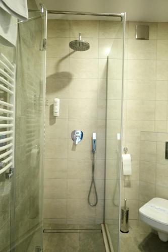 a shower with a glass door and a toilet at Brooklyn Noclegi in Jasło