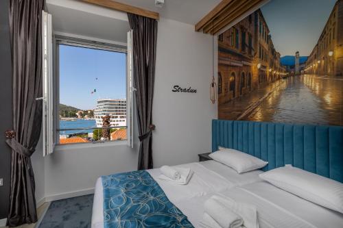 a bed in a room with a large window at Apartments and Rooms Villa Naida in Dubrovnik