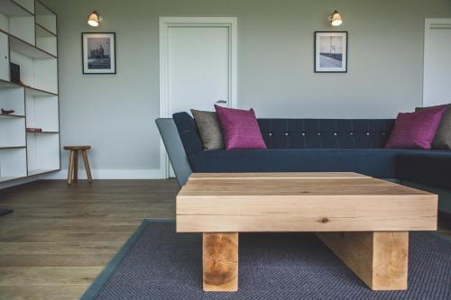 a living room with a blue couch and a wooden coffee table at John O'Groats in John O Groats