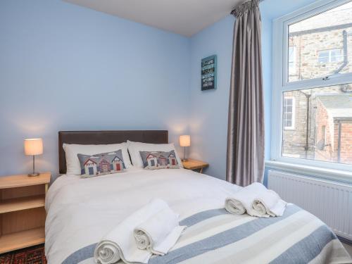 ein Schlafzimmer mit einem Bett mit Handtüchern darauf in der Unterkunft Gadlys House - Waters Edge in Beaumaris
