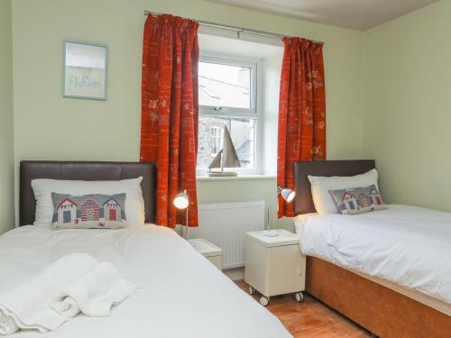 sypialnia z 2 łóżkami i oknem w obiekcie Gadlys House - Beau View w mieście Beaumaris