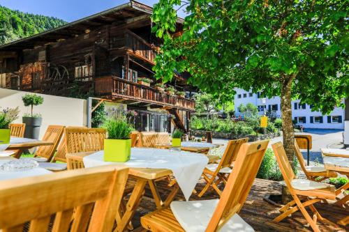 a patio with tables and chairs and a building at Hotel Oberschmied in Reit im Winkl