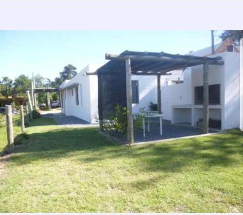 a house with a patio with a table in the yard at Maga in Piriápolis