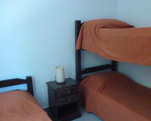 um quarto com 2 beliches e uma mesa de cabeceira em Maga em Piriápolis