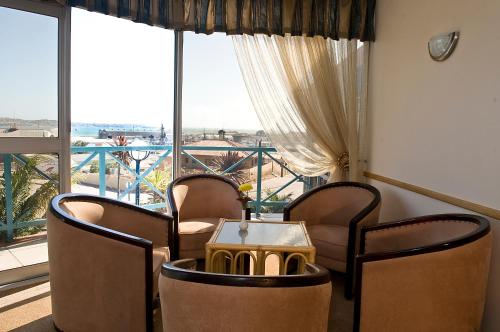 a room with two chairs and a table and a large window at Sea-View Zum Sperrgebiet in Lüderitz