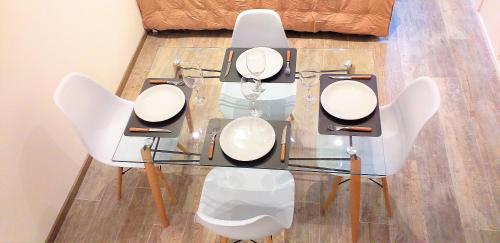 una mesa de cristal con sillas blancas encima en Departamento en el centro de Bariloche, en San Carlos de Bariloche