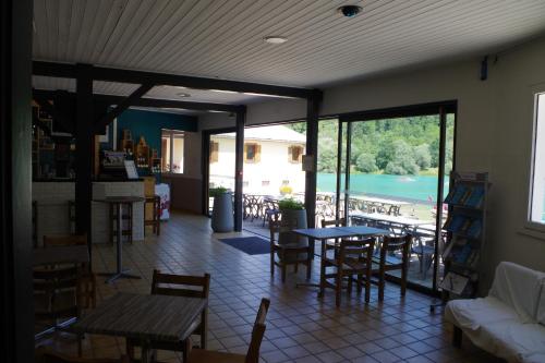 a restaurant with tables and chairs and a view of a lake at Eau Vive in Lescheraines
