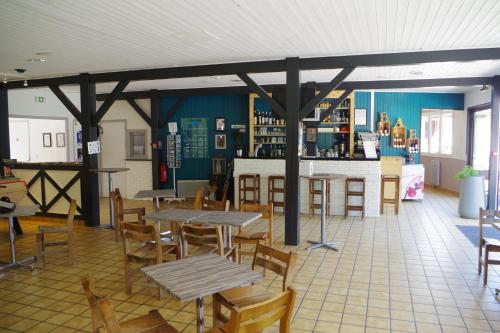 a restaurant with wooden tables and chairs and a bar at Eau Vive in Lescheraines