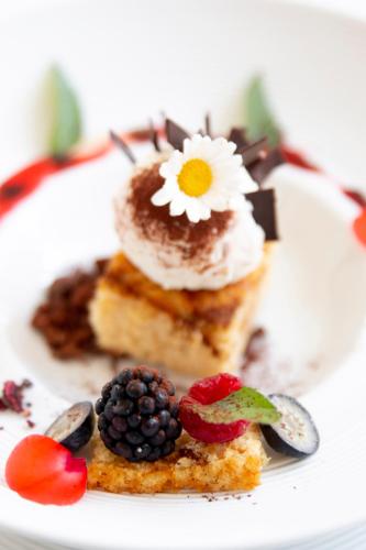 a white plate with a dessert with a flower on it at Art Hotel Kaštieľ in Tomášov
