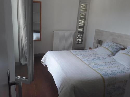 a bedroom with a white bed and a mirror at VILLA BONVOULOIR in Bagnères-de-Bigorre