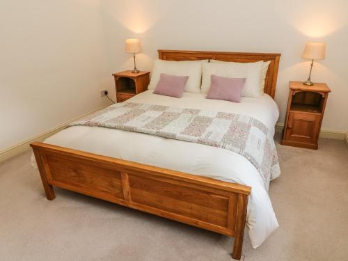 a bedroom with a large bed with two night stands at Spens Farm Cottage in Lancaster