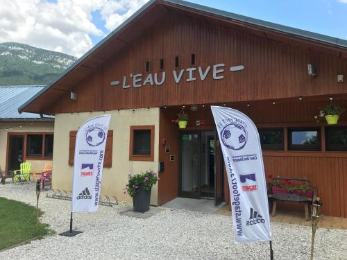 a building with two flags in front of it at Eau Vive in Lescheraines