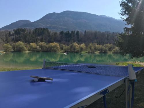 a ping pong table in front of a lake at Eau Vive in Lescheraines