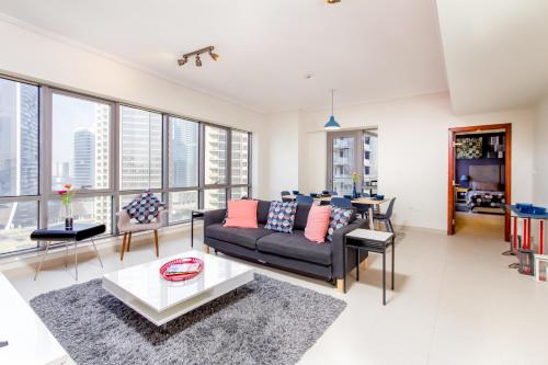 a living room with a couch and a table at Quintessential Quarters - Ultra-modern and Spacious Aparment in Dubai