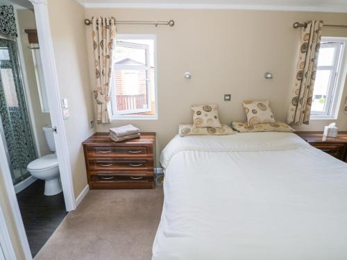 1 dormitorio con cama, aseo y ventana en Booster's Lodge en Stratford-upon-Avon