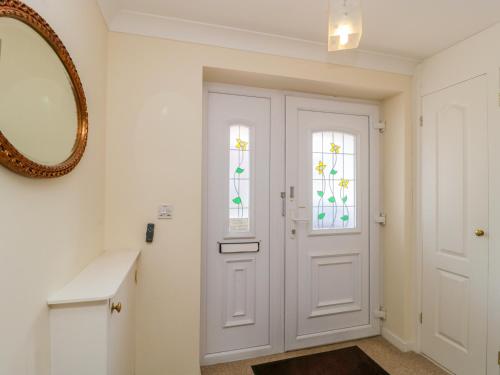 a bathroom with a white door and a mirror at 27 Wick Lane in Christchurch