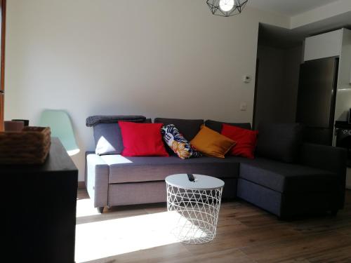 a living room with a couch with colorful pillows at Apartamentos La Réunion in Camarena de la Sierra