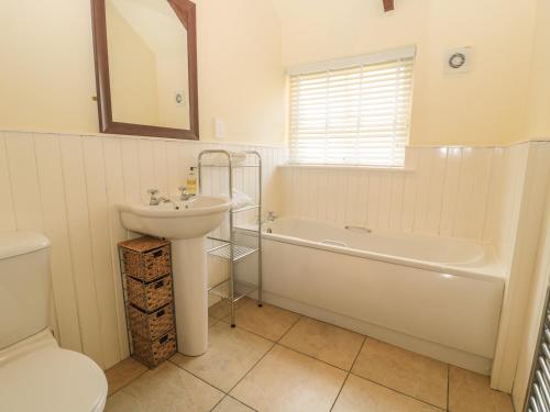 uma casa de banho com um lavatório, uma banheira e um WC. em Nursery Cottage em Morpeth