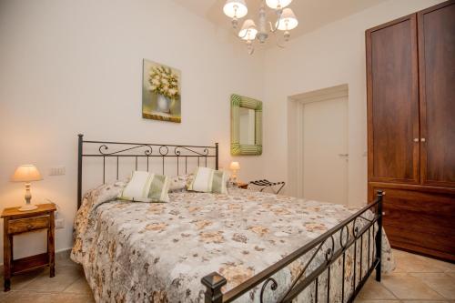 a bedroom with a large bed and a wooden cabinet at Agriturismo Colle Oliveto in Orbetello