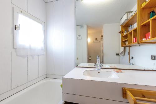 une salle de bain blanche avec un lavabo et une fenêtre dans l'établissement Superbe Duplex 45m2, au pied des pistes, La Plagne, avec WIFI, à Les Coches