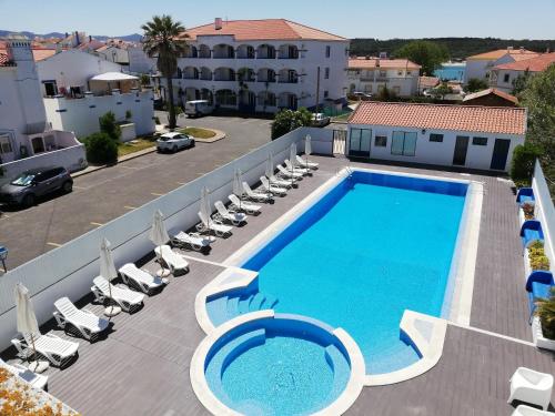 an overhead view of a swimming pool with lounge chairs at Hotel Eira Da Pedra in Vila Nova de Milfontes