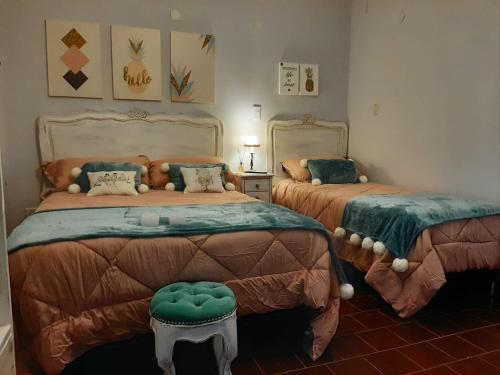 una camera con due letti e uno sgabello di Apart La Nona a San Lorenzo