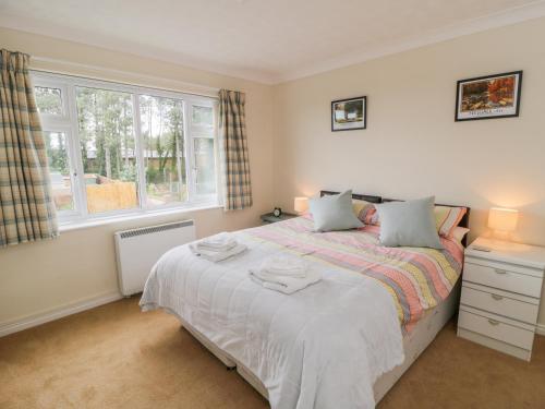 a bedroom with a bed with white sheets and a window at Sea-u-Soon in Saltburn-by-the-Sea