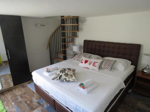 a bedroom with a bed with white sheets and pillows at Apartman Crnica in Šibenik