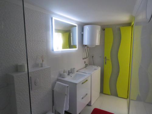 a bathroom with a white sink and a mirror at Apartman Crnica in Šibenik