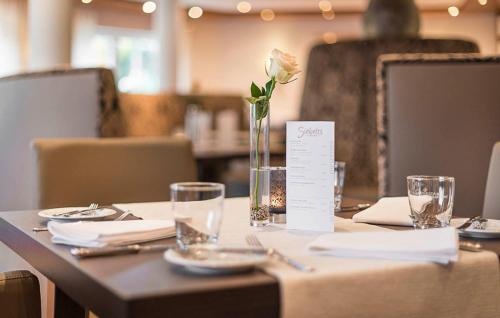 une table avec une fleur dans un vase dans l'établissement Motel B, à Bocholt