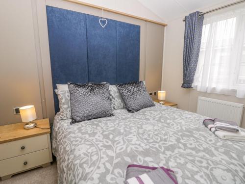 a bedroom with a large bed with a blue headboard at Cayton Pines in Scarborough