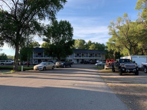 a parking lot with cars parked in front of a building at The Gunnison Inn at Dos Rios Golf Course in Gunnison