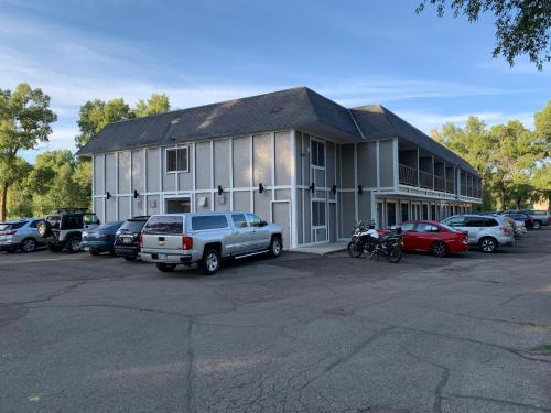 a building with cars parked in a parking lot at The Gunnison Inn at Dos Rios Golf Course in Gunnison