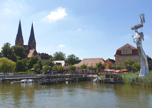 a view of a river with a town and a church at Travel Art Boardinghouse in Neuruppin