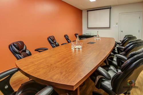 a conference room with a large wooden table and chairs at Chateau Roberval in Roberval