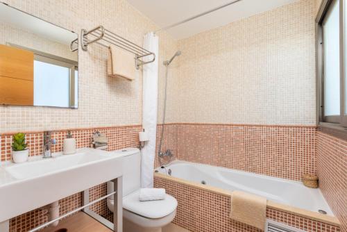Un baño con lavabo, inodoro y bañera. en Villa 26, en Cala'n Bosch