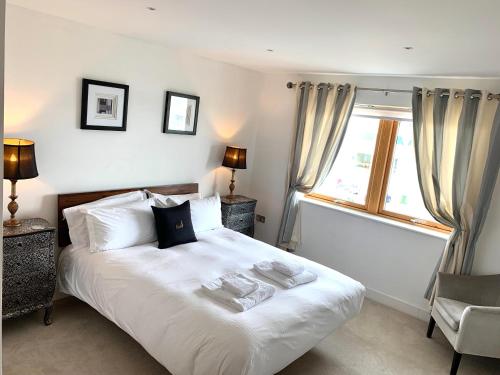 a bedroom with a white bed and a window at 4-bedroom Penthouse - Fistral Beach in Newquay