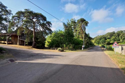 an empty road with trees on the side of the road at Le Moulin du Cluzeau in Chaillac